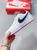 Side view of the white Nike sneaker with a contrasting black Swoosh, white midsole and red outsole.