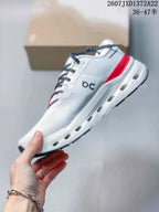 Side view of the white sneaker showing On branding, red heel detail, black outsole accents, and sole openings.