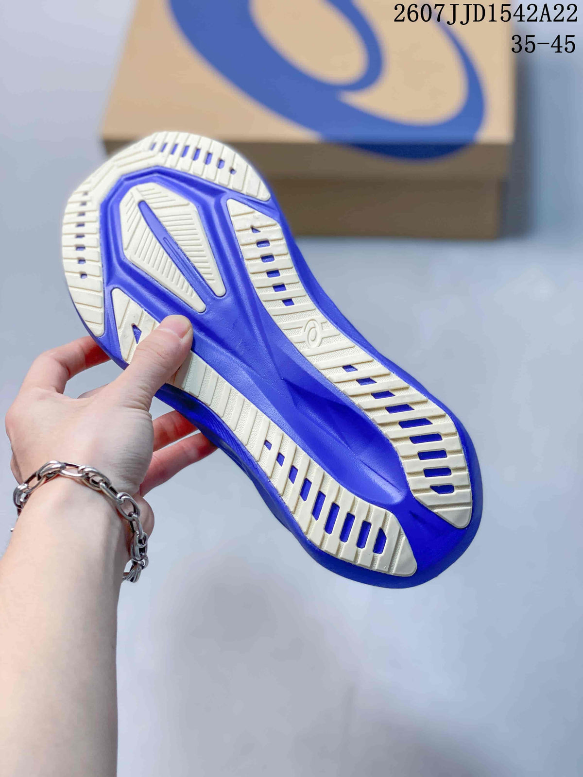 Underside view showing the purple and off-white segmented outsole of the ASICS running shoe.