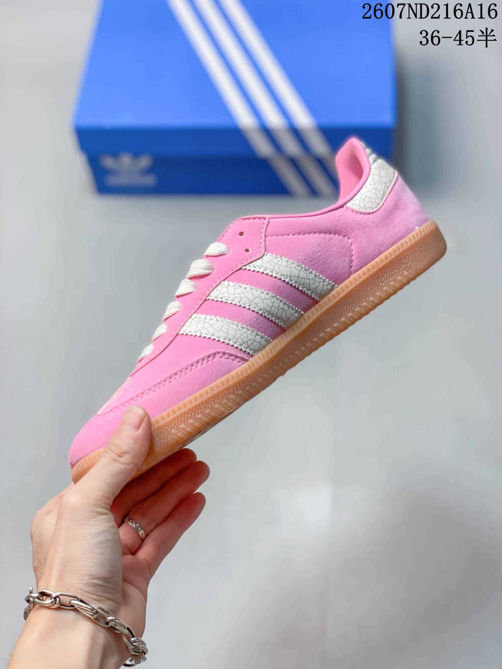 Side view of the pink adidas Samba sneaker with white three-stripe detailing and a gum-colored outsole.