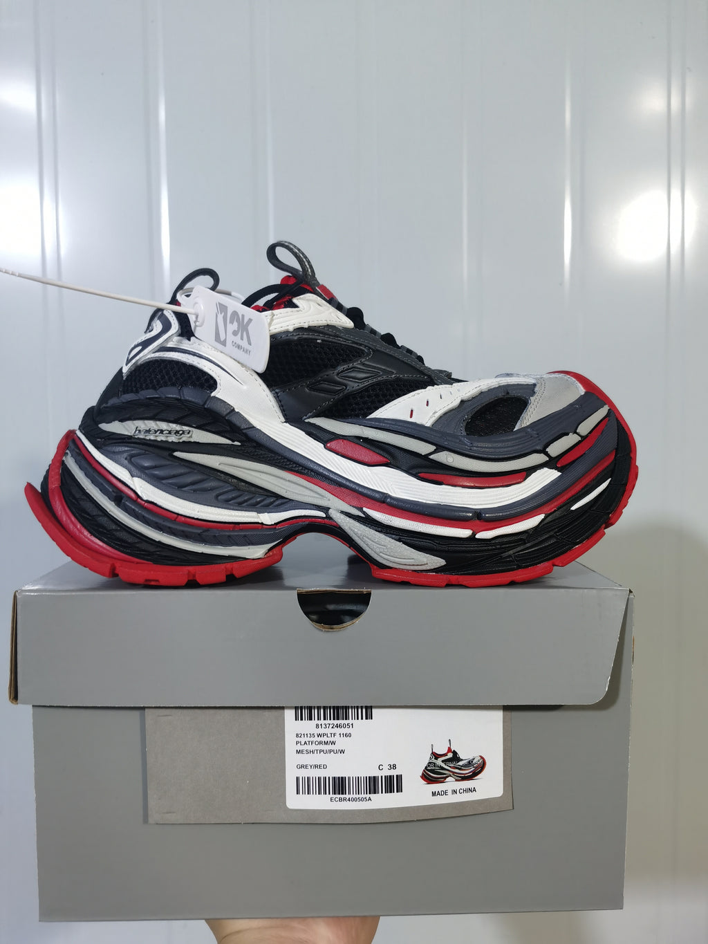 New Balance 1160 sneakers in grey, black, white and red displayed on a labeled shoe box; the box shows a photographed size C 38.