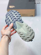 Underside view of the sneaker showing the patterned lugged outsole with multiple raised traction blocks.