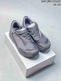 Pair of gray On sneakers displayed on a white box, showing the layered upper, mesh panels, laces, and padded collars.