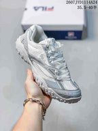 Angled side view showing the white and gray upper, FILA side branding, and low-profile outsole.