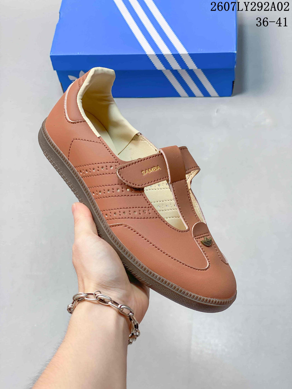 Angled side view of the brown Samba Jane-style sneaker showing the Mary Jane strap, perforated side panels, and gum-colored outsole.