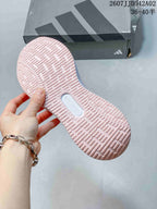 Underside of a pink running shoe showing its patterned outsole.