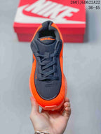 Top view showing the black mesh-style toe box, laces, tongue, and orange upper.