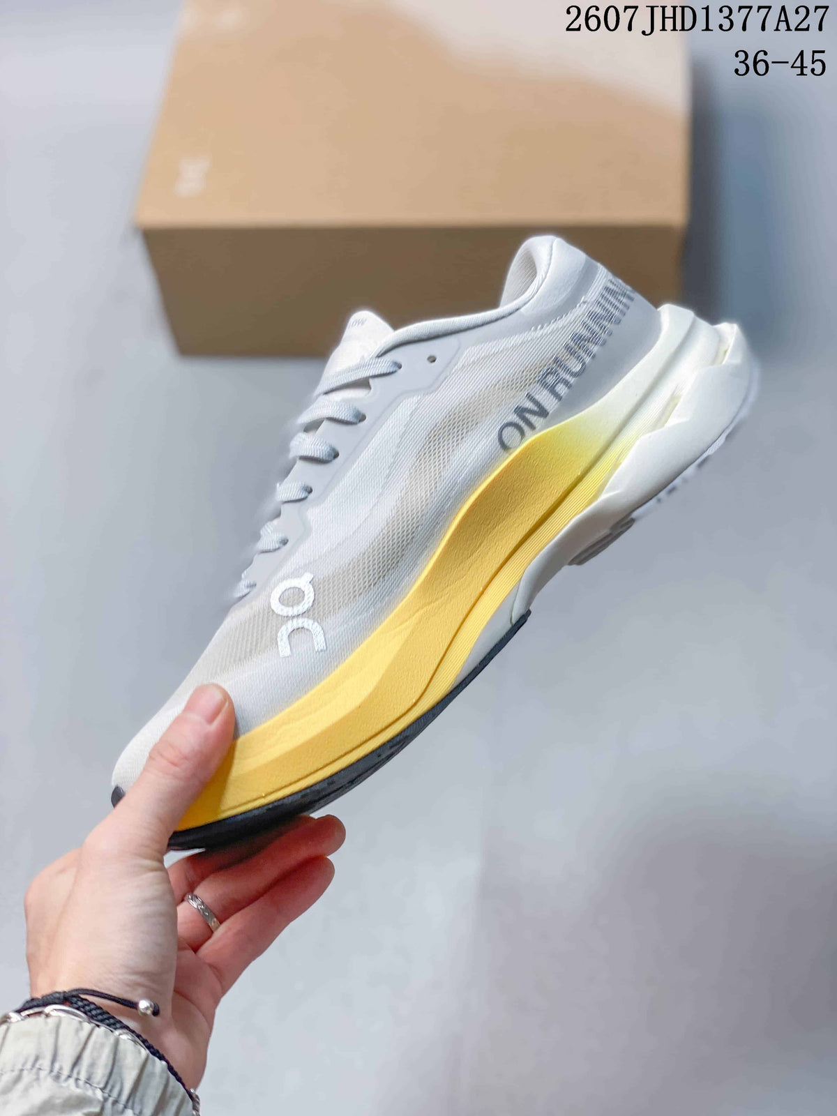 Side view of the white On sneaker with layered upper panels, yellow midsole, and black outsole edge.