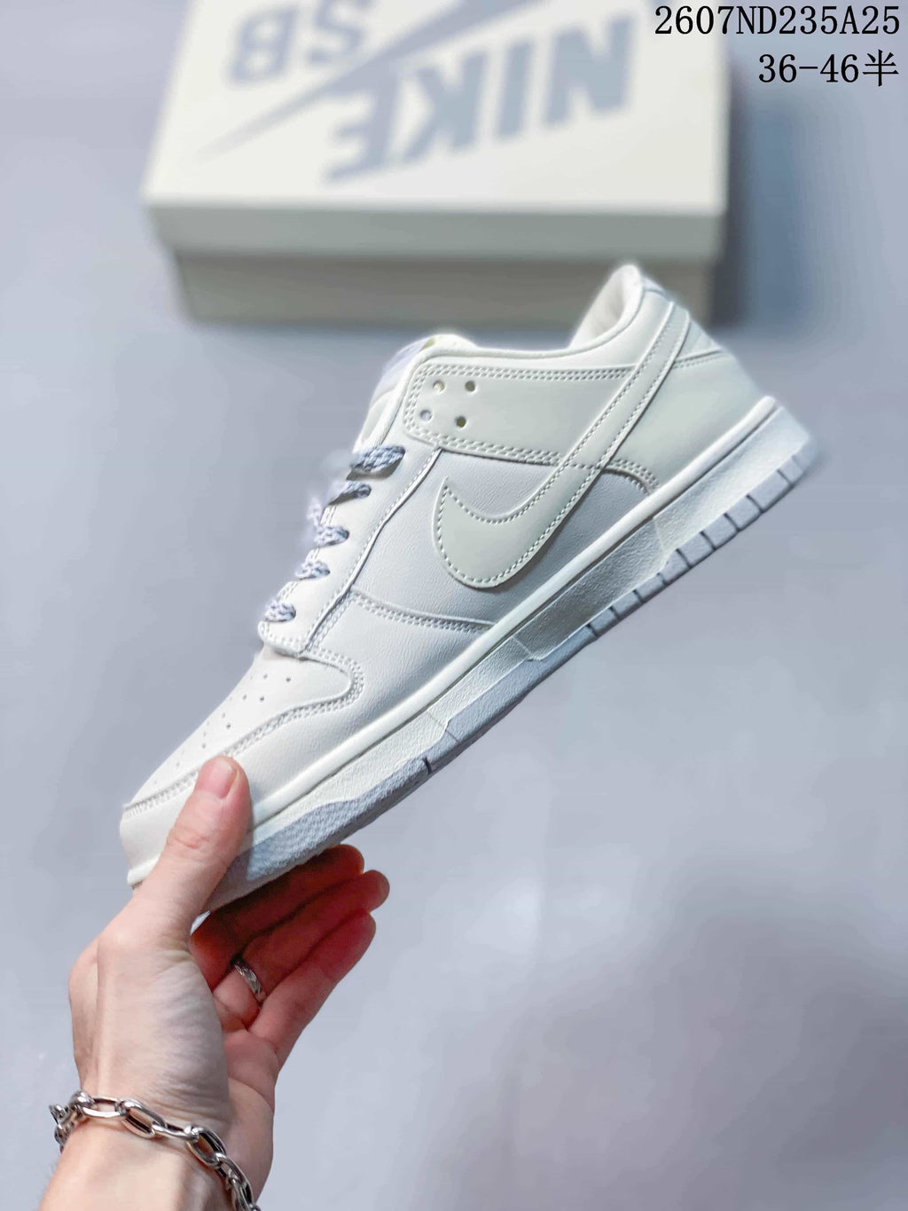 Side profile of the white low-top sneaker showing the layered panels, Swoosh detail and textured outsole.