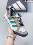 Angled side view highlighting the green stripes, beige panels, burgundy details and navy toe bumper.