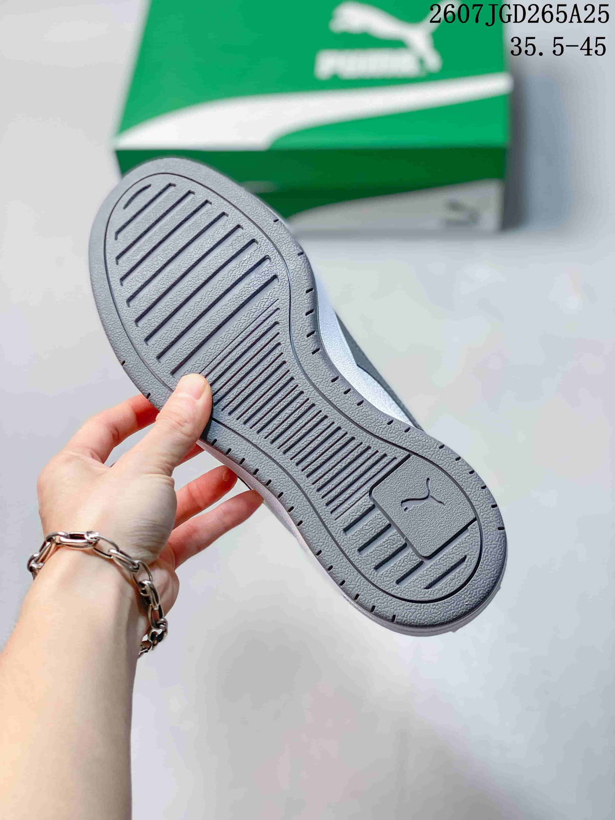 Close-up of the textured outsole on a white and gray PUMA sneaker.