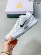 Side profile of the white basketball shoe showing the black side logo, speckled midsole, and translucent outsole.