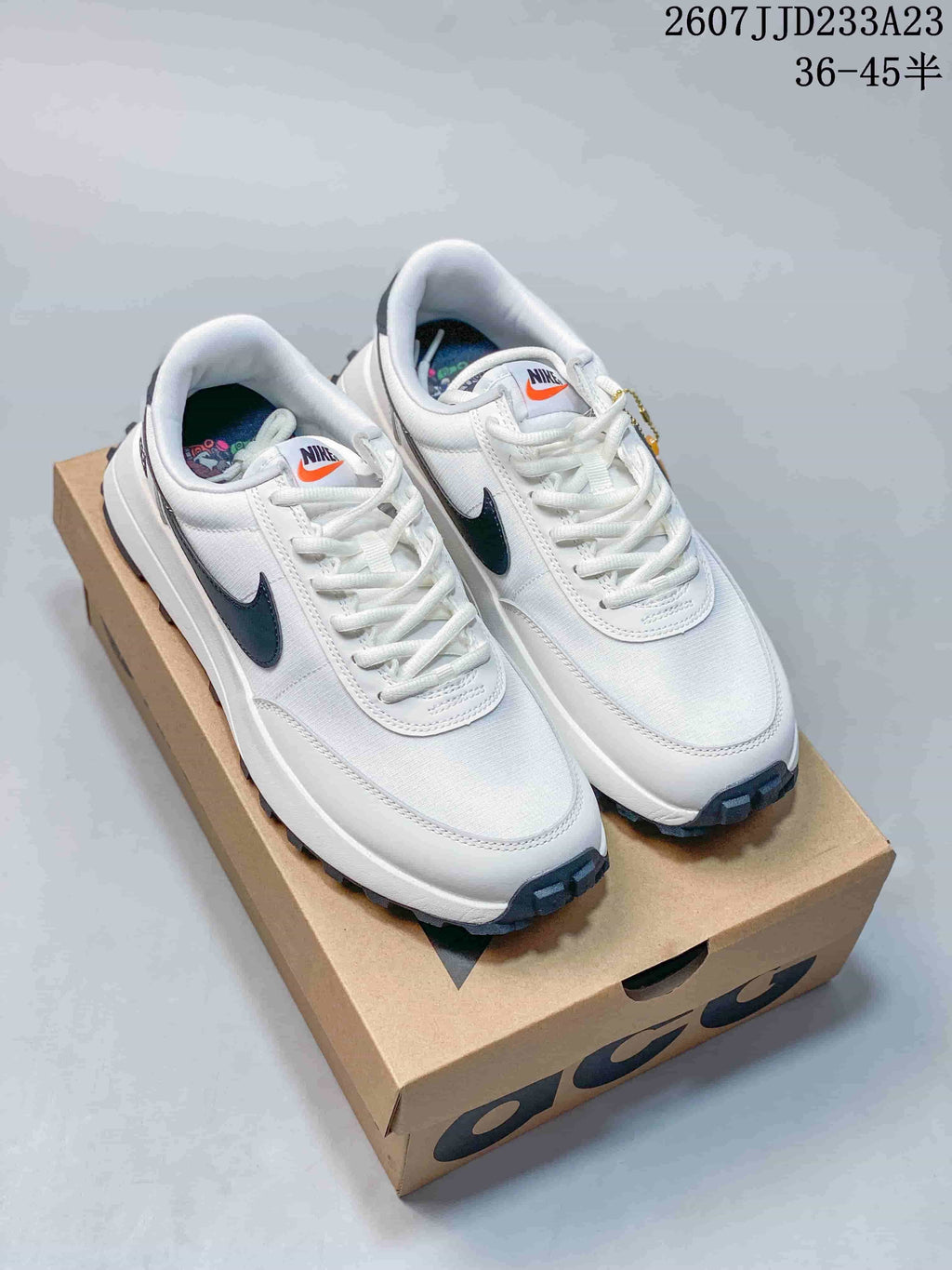 White and navy Nike ACG LDV sneakers displayed on a shoebox, with the source size range and code overlaid above.