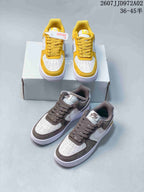 Yellow and white and brown and white low-top Nike Air Force 1 '07 sneakers shown together