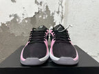 Front view of pink and black low-top basketball shoes with black laces and white midsoles.