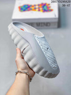 Side view of a white Nike Mind 001 slide showing the perforated upper, side swoosh, and ridged outsole.