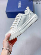 Side view of the white sneaker showing perforated panels, layered sole construction and lace eyelets.