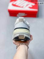 Rear view of the sneaker showing the padded heel, pull tab, layered cream midsole and black outsole accents.