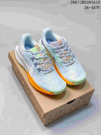 Pair of Nike Pegasus Trail 5 sneakers in light blue with lime green and orange accents, displayed on a shoe box.