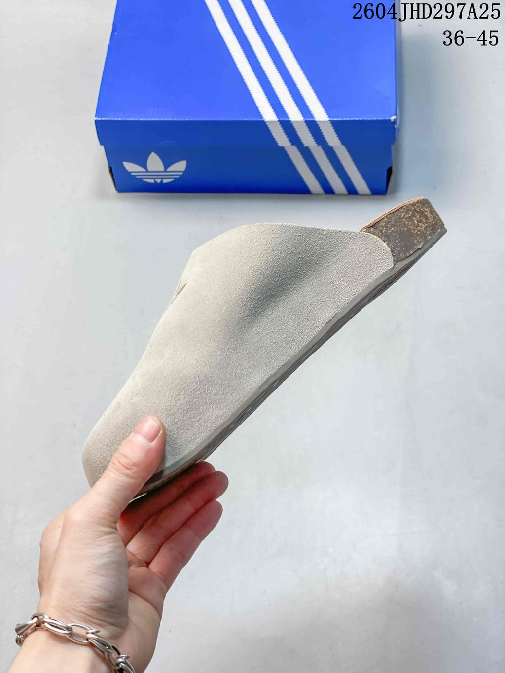 Side profile of a light neutral adidas Adimule slipper.