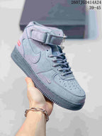 Three-quarter side view of the gray Nike high-top sneaker showing the Swoosh detail, perforated toe box, ankle strap, and textured sole.
