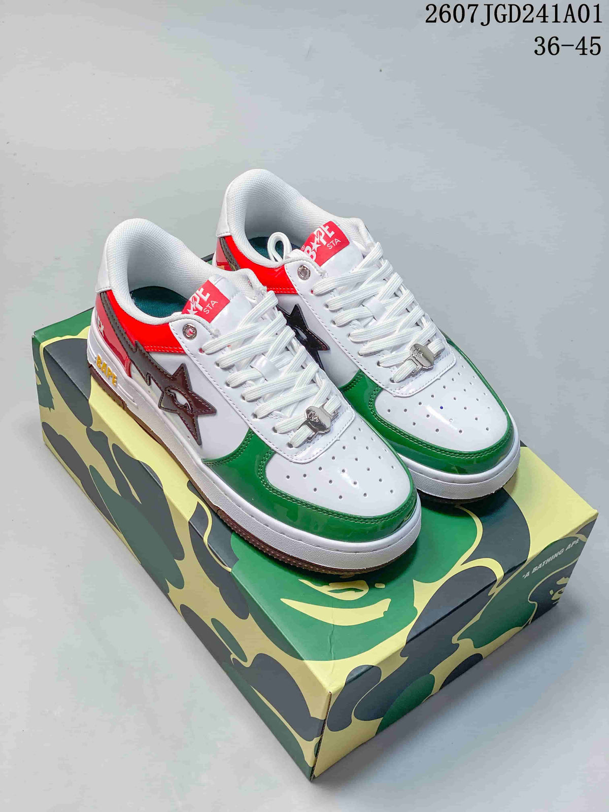 White low-top sneakers with green, red, and brown color blocking, shown as a pair on a patterned box.