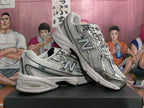Two silver-tone New Balance 530 sneakers shown in a side and angled view.