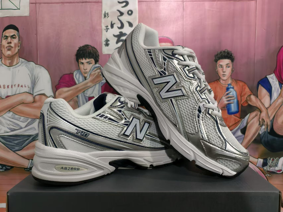 Two silver-tone New Balance 530 sneakers shown in a side and angled view.