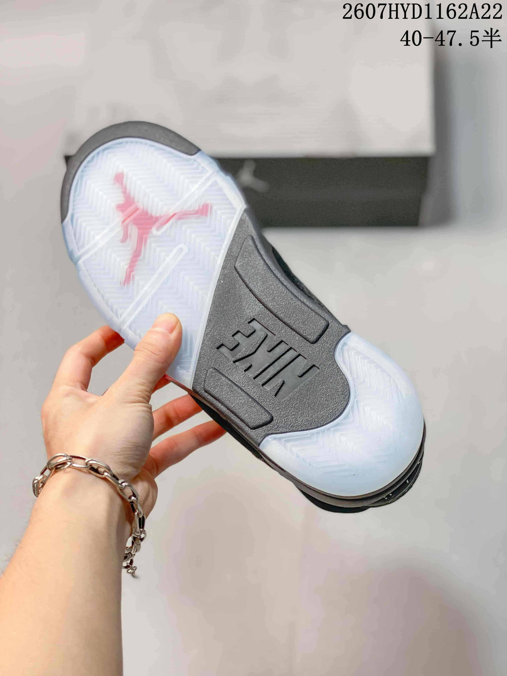 Bottom view of the sneaker showing a translucent herringbone-pattern outsole and a contrasting red Jordan graphic.
