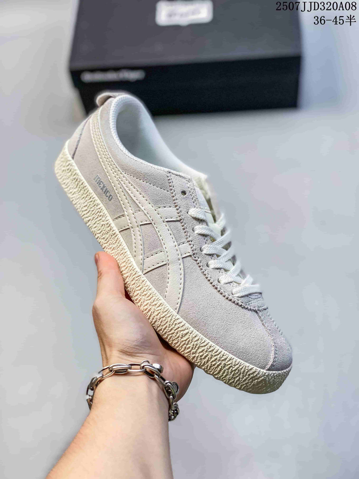 Angled side view of the light gray ASICS Japan S sneaker showing the side branding, layered stripes, laces, and textured outsole.
