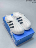 White adidas adiFOM Superstar Mule slides with black stripes shown on a blue box