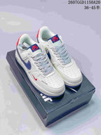 Pair of white low-top Nike sneakers with blue and red accent details, patterned laces, and a perforated toe box.