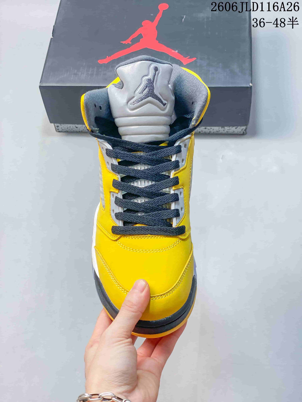 Front view of the high-top sneaker with dark laces and a gray tongue