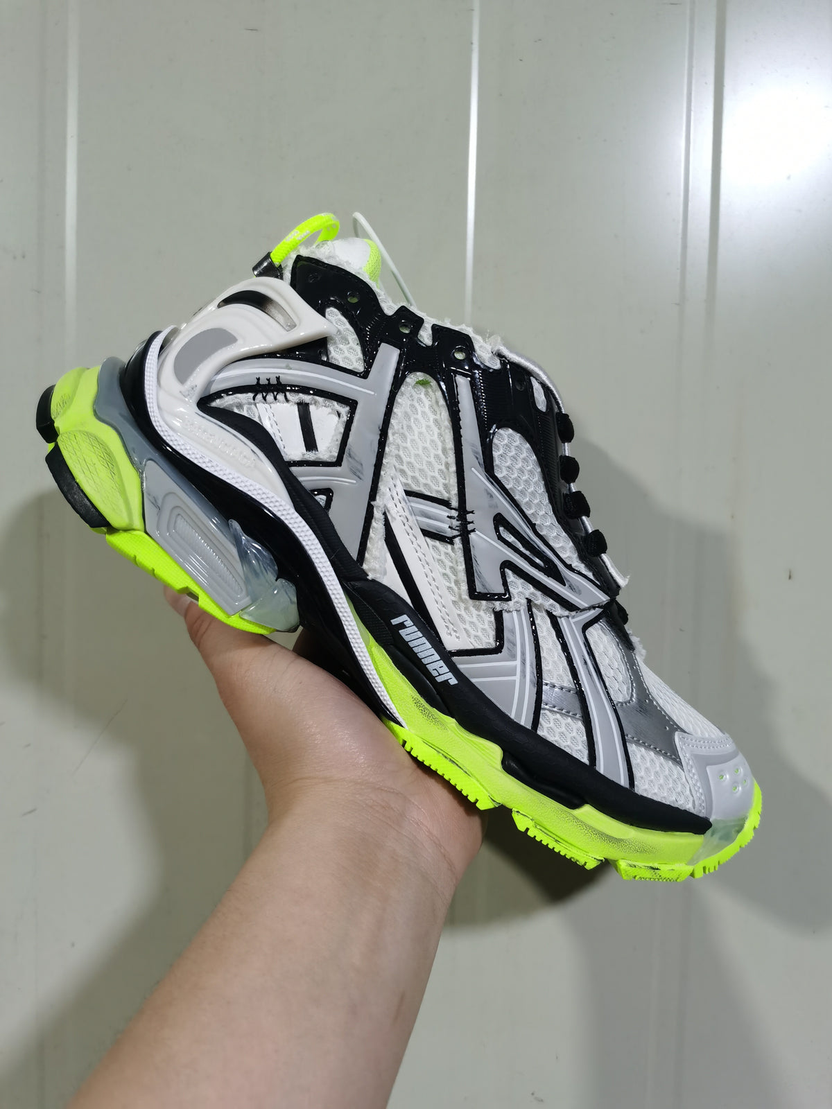 Front three-quarter view showing the mesh upper, black overlays, white panels and neon yellow outsole.