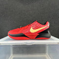 Side view of a red and black Nike basketball sneaker with a pale yellow Swoosh and Zoom text on the midsole.