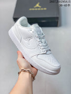Angled side view of the white Air Jordan 1 Low sneaker showing the toe, stitched overlays, side logo and low collar.