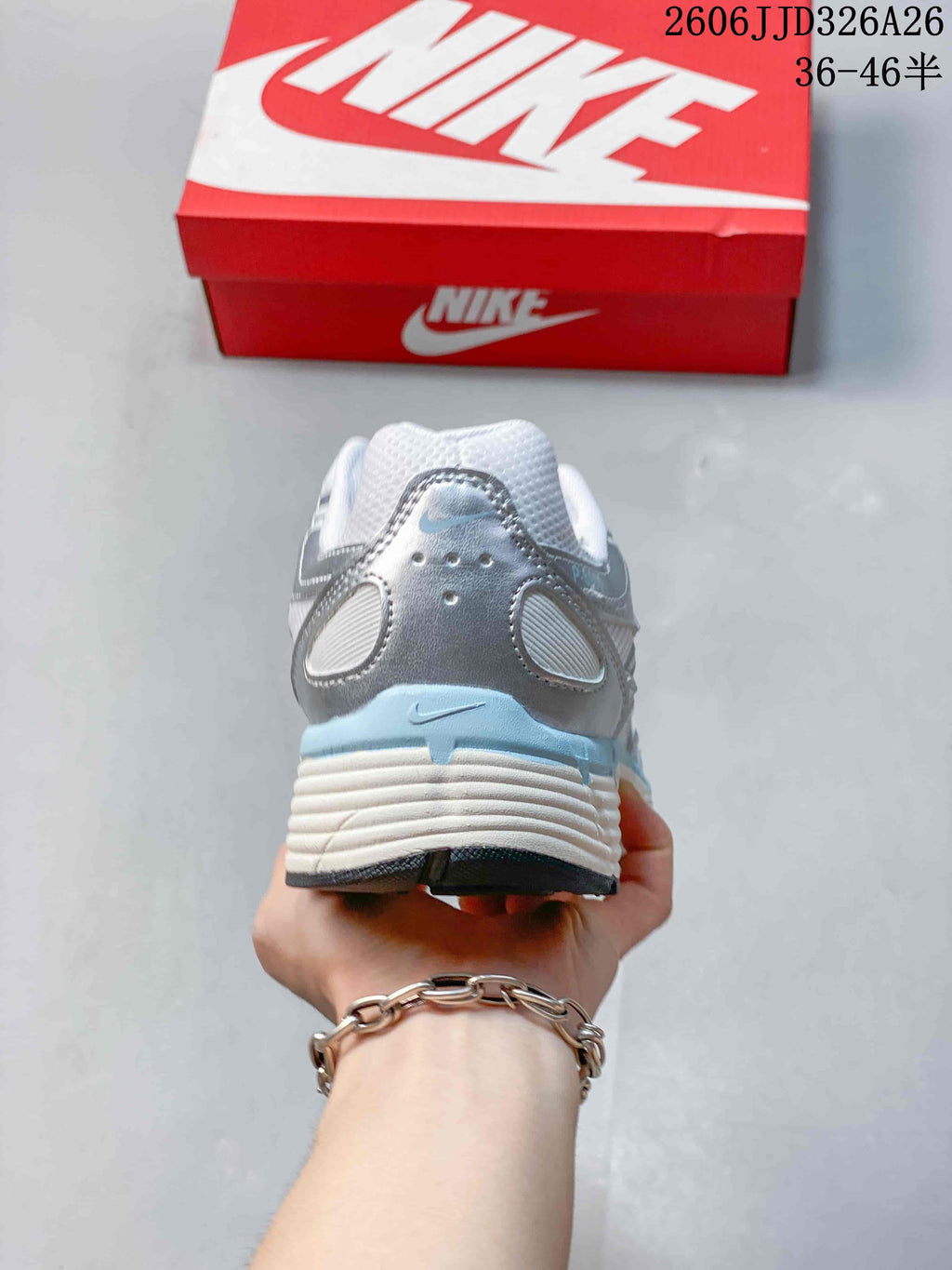 Rear view of a silver and white Nike P-6000 sneaker with pale blue heel accents