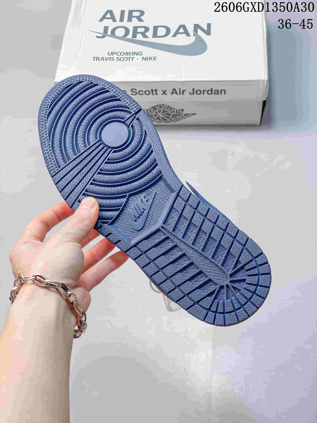 Blue outsole of the low-top sneaker, with the box in the background