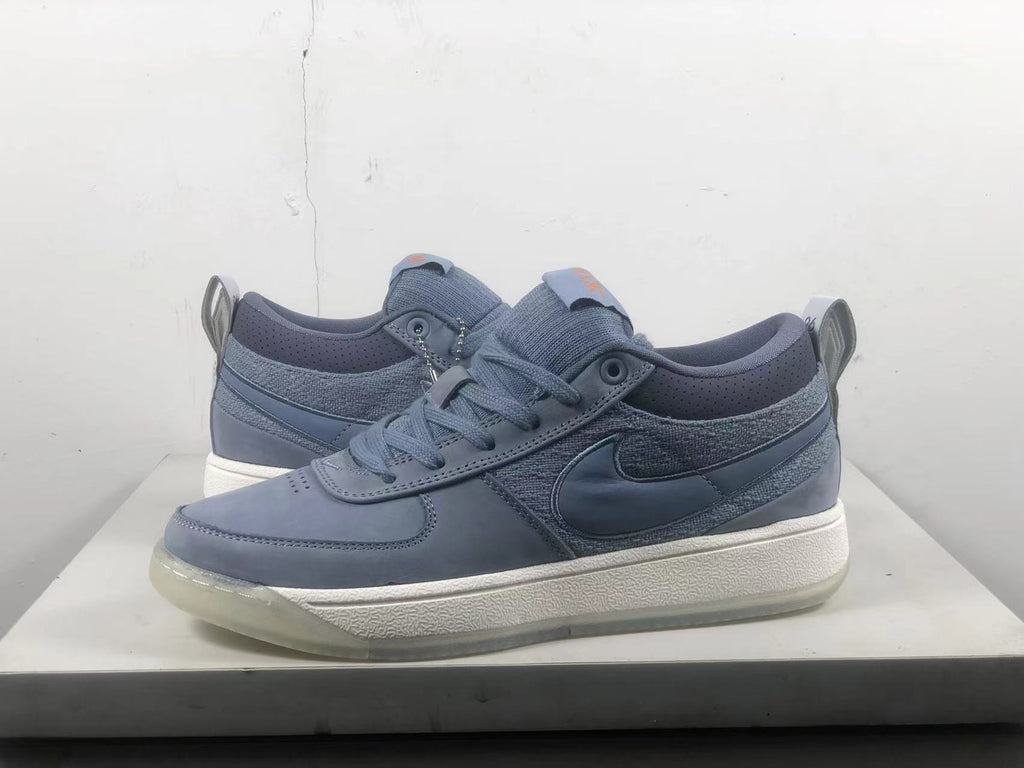 Pair of blue-gray Nike Book 1 shoes shown from the side, with lace-up closures and Swoosh details.