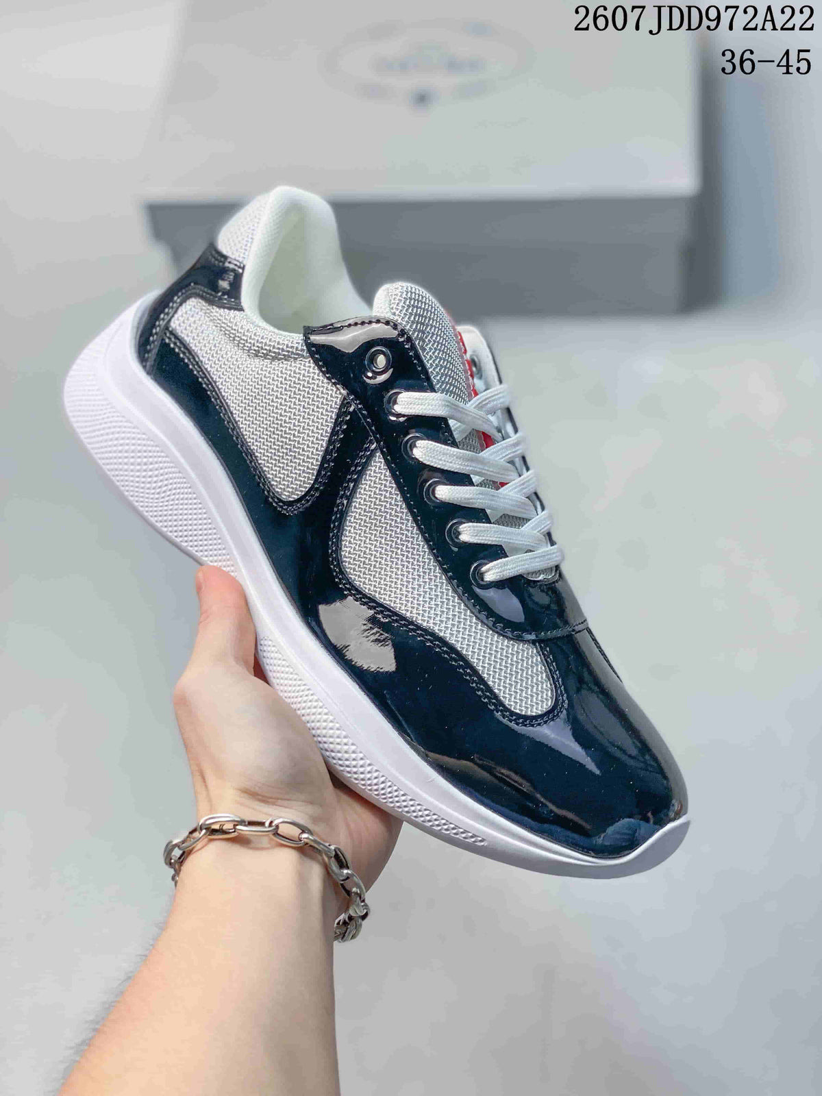 Black and white Prada America's Cup low-top sneaker with glossy overlays and textured panels.