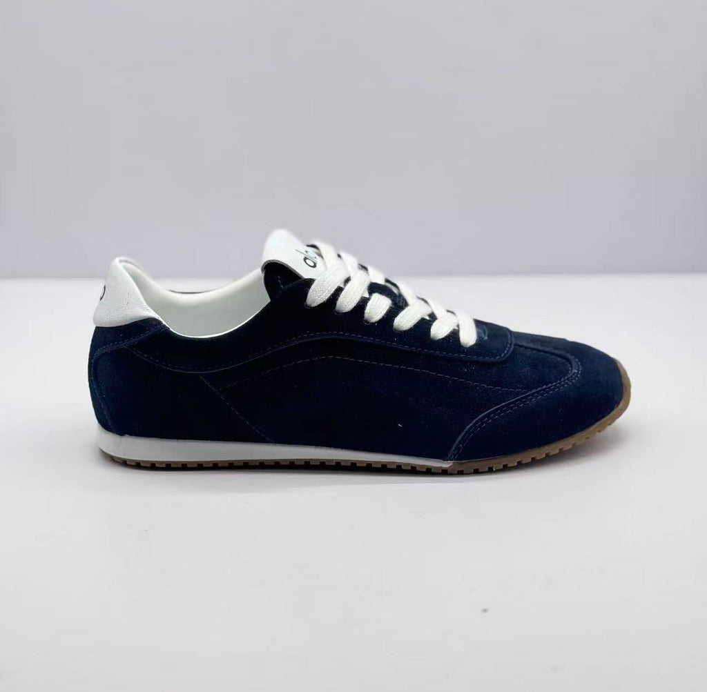 Opposite side view of the deep blue lace-up sneaker showing its low-profile shape and contrasting white collar.