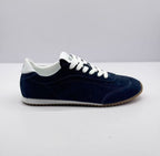 Opposite side view of the deep blue lace-up sneaker showing its low-profile shape and contrasting white collar.