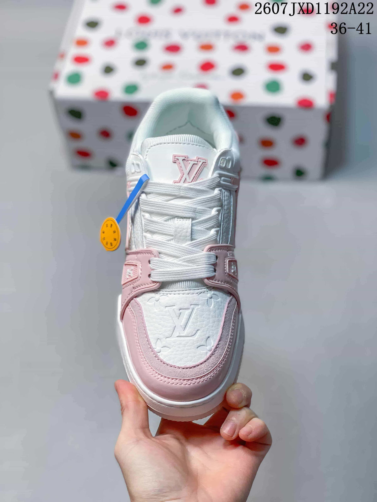 Top view showing the embossed monogram toe panel, pink trim and white laces.