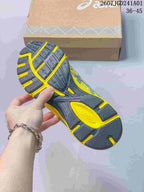 Underside of the ASICS sneaker showing a patterned charcoal and yellow outsole.
