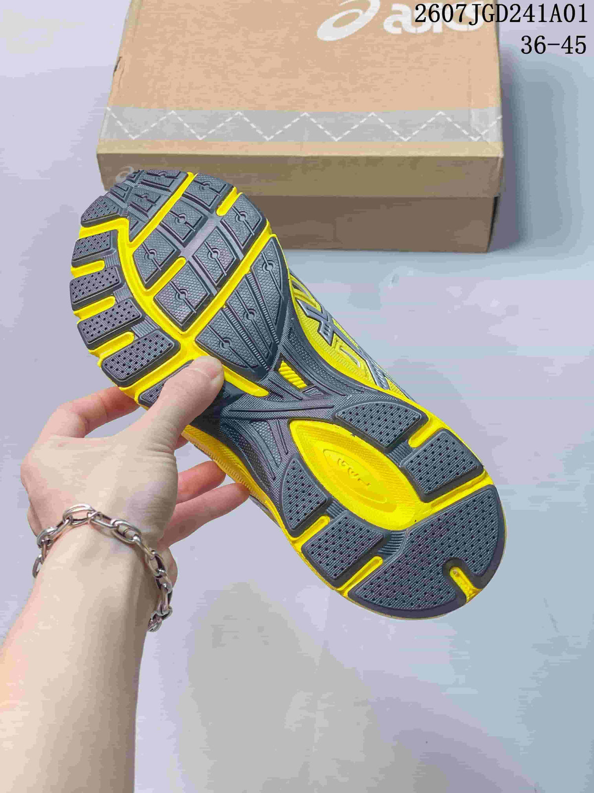 Underside of the ASICS sneaker showing a patterned charcoal and yellow outsole.
