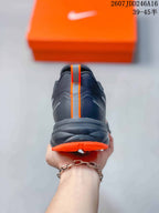 Rear view of the sneaker showing the padded heel, vertical orange detail, and orange outsole edge.