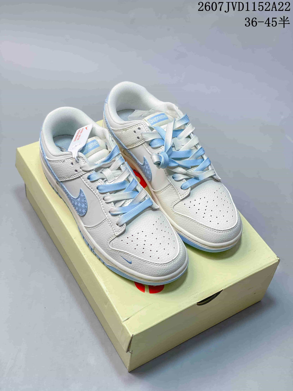 Pair of white and light blue Nike low-top sneakers displayed on a shoebox.
