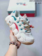 Angled side view of the FILA Croissant sneaker showing white panels, teal and red accents, and a beige outsole edge.