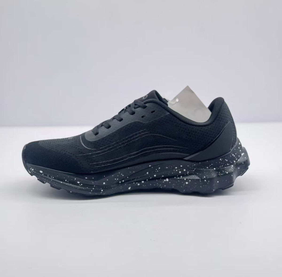 Side view of the plain black outer profile, showing the lace-up upper and segmented outsole.
