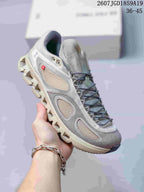 Light gray and beige On sneaker with mesh panels, dark laces, and a pale segmented outsole.